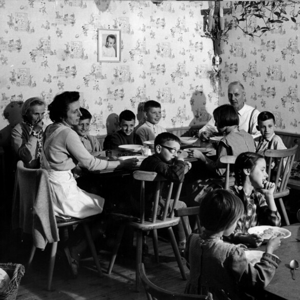 Historisches Bild: Pflegeeltern mit Kindern am Esstisch