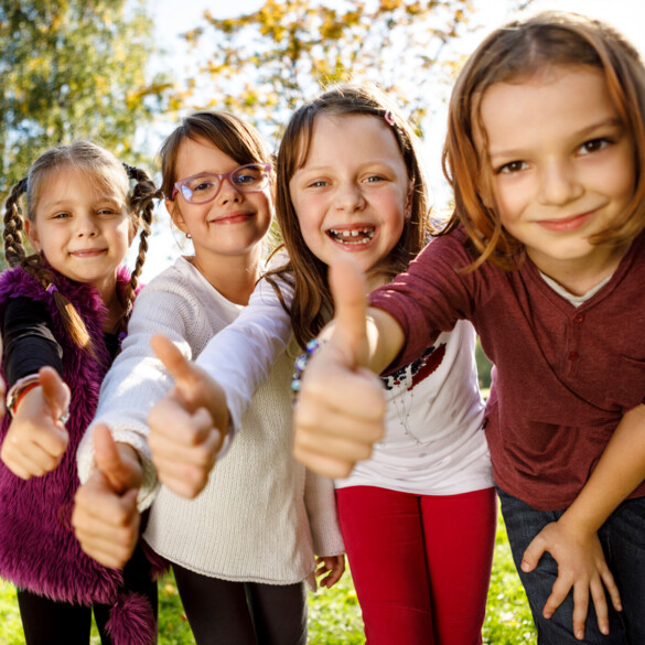 vier Kinder zeigen den Daumen hoch