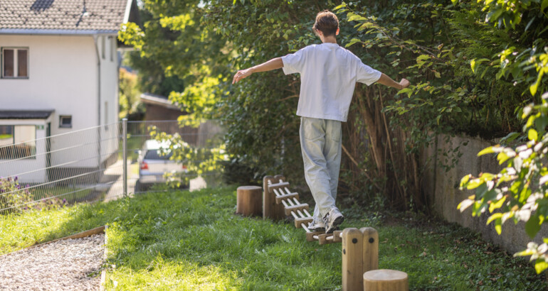 Jugendlicher balanciert über ein Niederseilgarten-Element