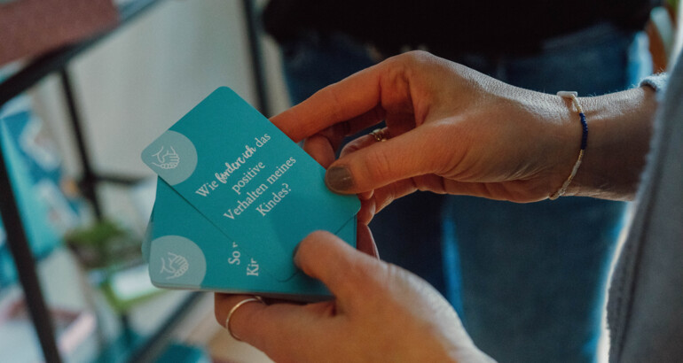 Nahaufnahme eine Kartendecks, mit sozialpädagogisch bezogenen Fragen darauf.  