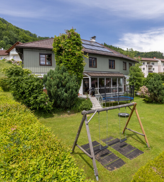 Außenansicht der Wohngemeinschaft mit Garten, Schaukel und Trampolin.